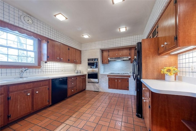 kitchen featuring sink, backsplash, and black appliances