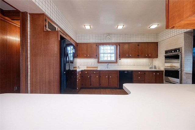 kitchen featuring sink, backsplash, and black appliances