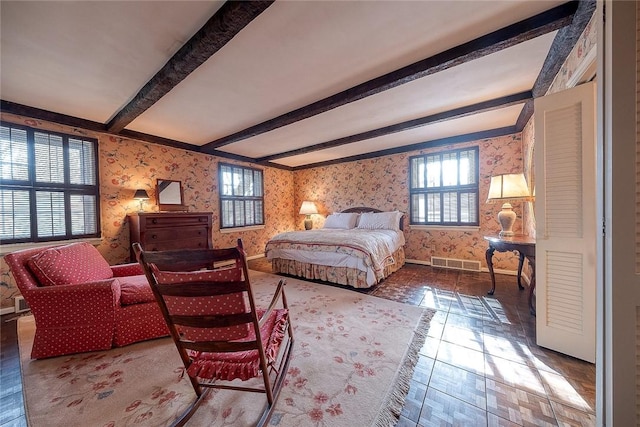 bedroom featuring multiple windows and beam ceiling