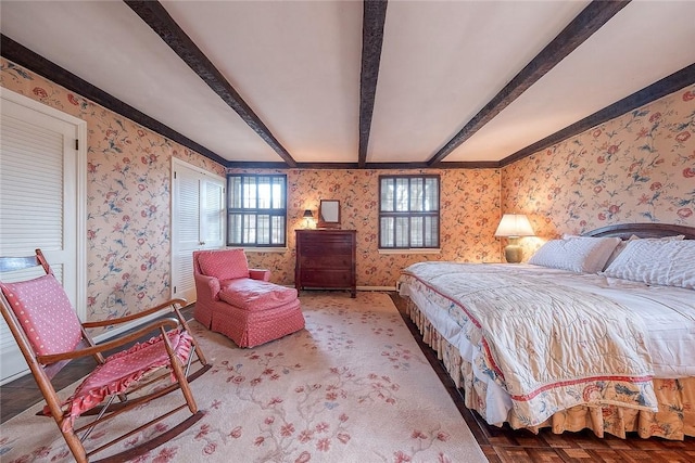 bedroom with parquet floors and beam ceiling