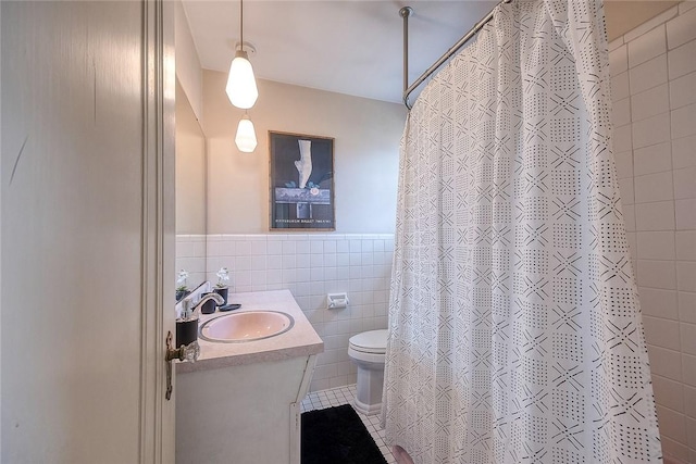 bathroom with curtained shower, tile walls, tile patterned flooring, vanity, and toilet