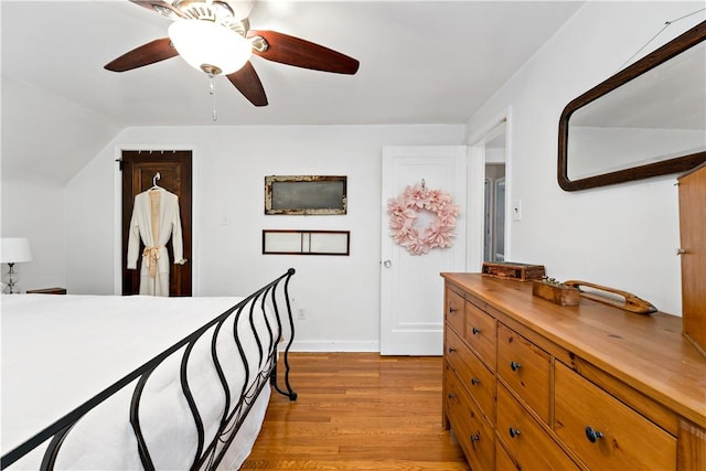 bedroom featuring ceiling fan, vaulted ceiling, and light hardwood / wood-style flooring