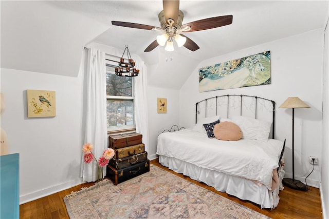 bedroom with hardwood / wood-style floors, vaulted ceiling, and ceiling fan