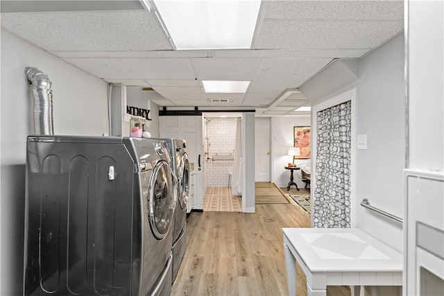 laundry area featuring separate washer and dryer and light hardwood / wood-style flooring