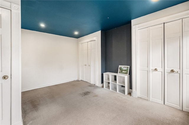 interior space featuring multiple closets and carpet floors