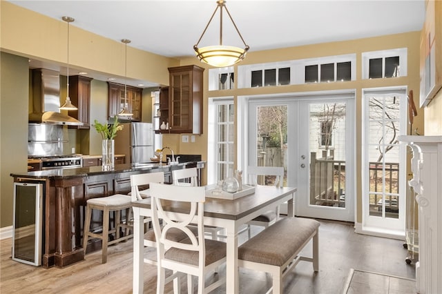 dining room with french doors and light hardwood / wood-style flooring