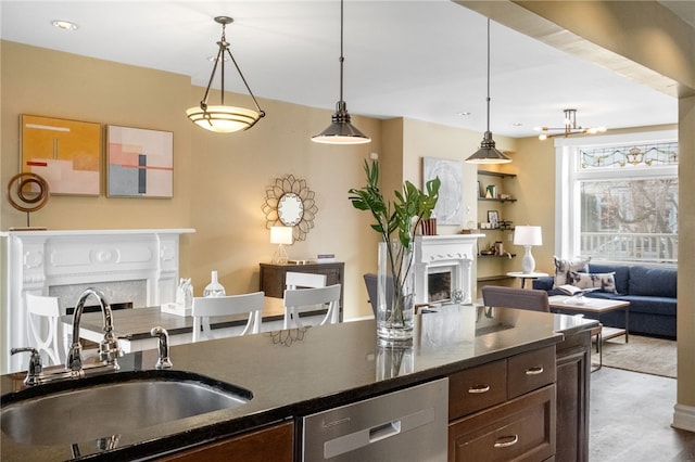 kitchen with pendant lighting, stainless steel dishwasher, sink, and dark brown cabinets