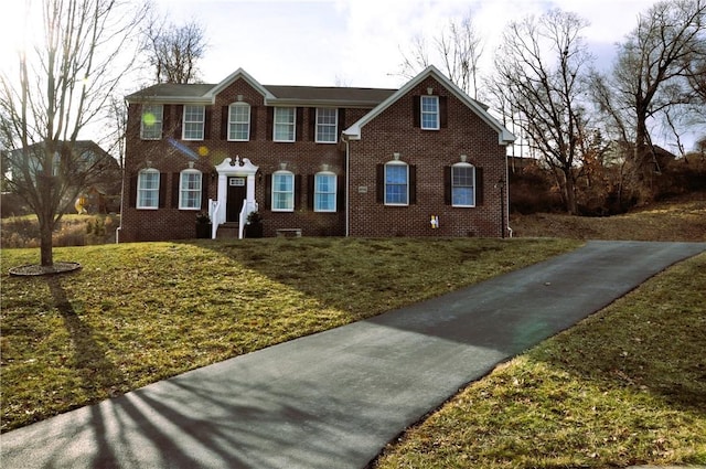 colonial house with brick siding and a front lawn