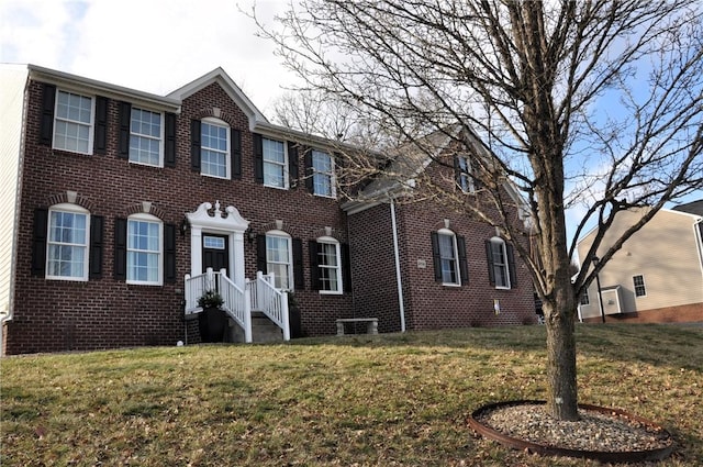 colonial-style house with a front lawn and brick siding