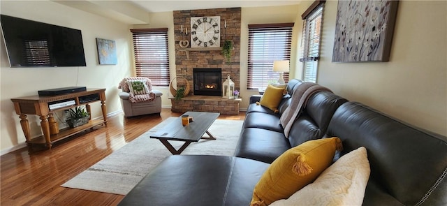 living room with a fireplace, wood finished floors, and baseboards