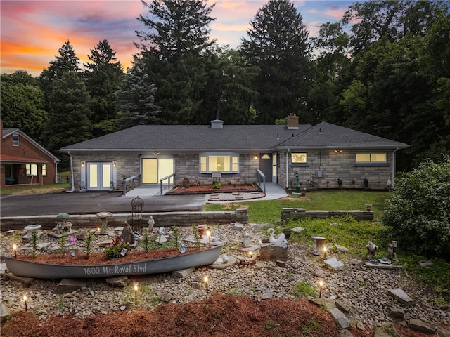 back house at dusk featuring a yard and french doors