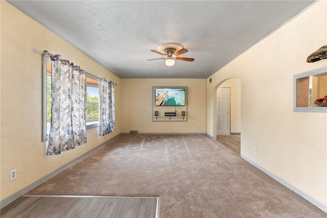 unfurnished living room with ceiling fan, light carpet, and a textured ceiling