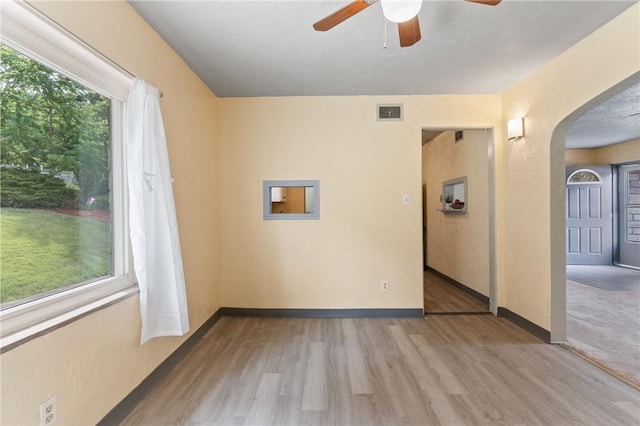 unfurnished room featuring light hardwood / wood-style flooring, plenty of natural light, and ceiling fan