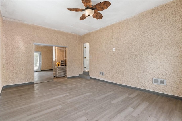 empty room with ceiling fan and hardwood / wood-style floors