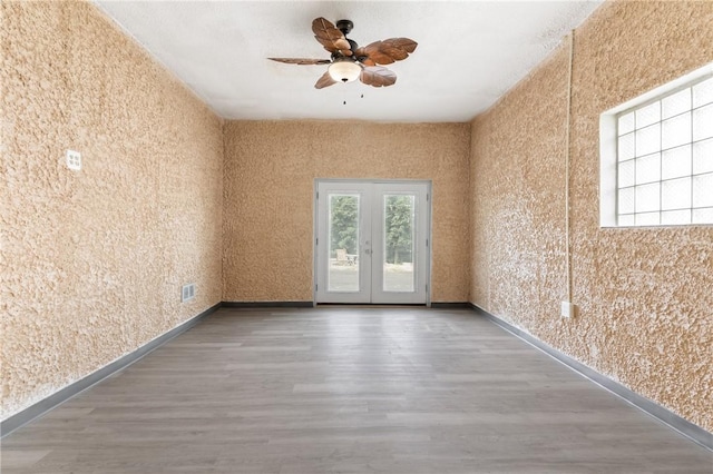 unfurnished room with hardwood / wood-style flooring, ceiling fan, and a wealth of natural light