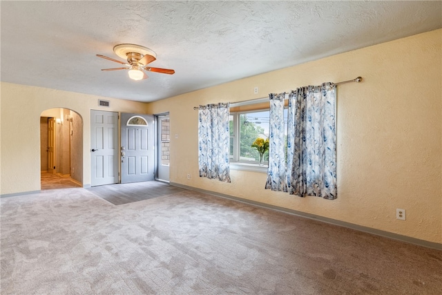 unfurnished bedroom with ceiling fan, carpet flooring, and a textured ceiling