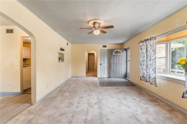 carpeted spare room with ceiling fan and a textured ceiling