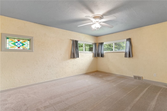 carpeted empty room featuring ceiling fan and a textured ceiling