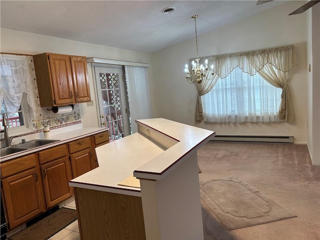 kitchen featuring pendant lighting, sink, a baseboard heating unit, a center island, and a notable chandelier