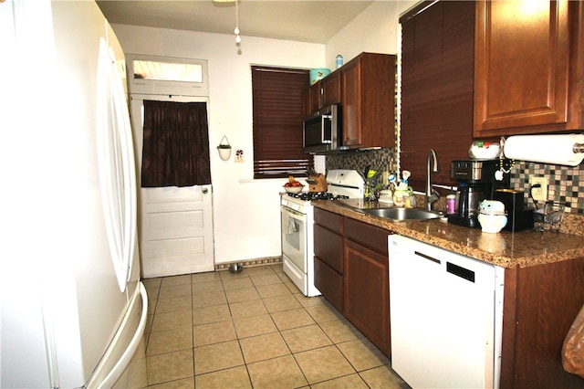 kitchen featuring tasteful backsplash, white appliances, sink, and light tile patterned floors