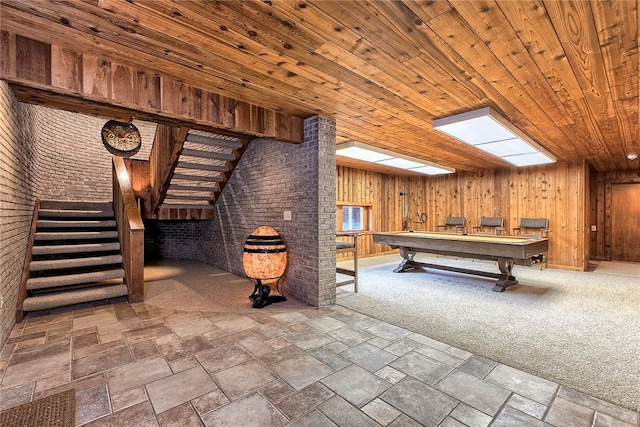 game room with pool table, wooden ceiling, wooden walls, carpet flooring, and brick wall