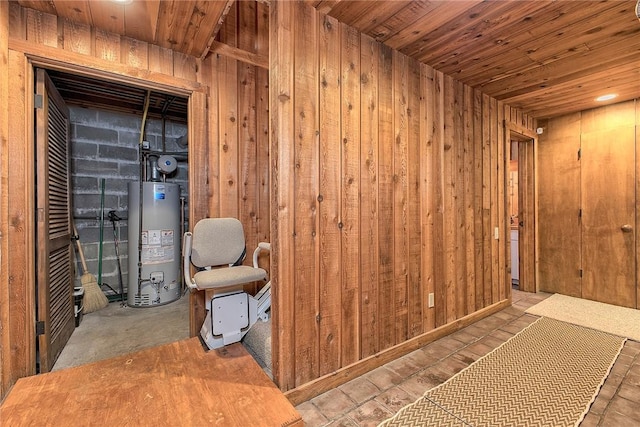 interior space featuring gas water heater, wood ceiling, and wooden walls