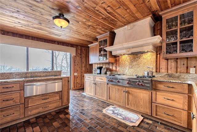 kitchen featuring premium range hood, light stone countertops, stainless steel gas cooktop, and wood ceiling