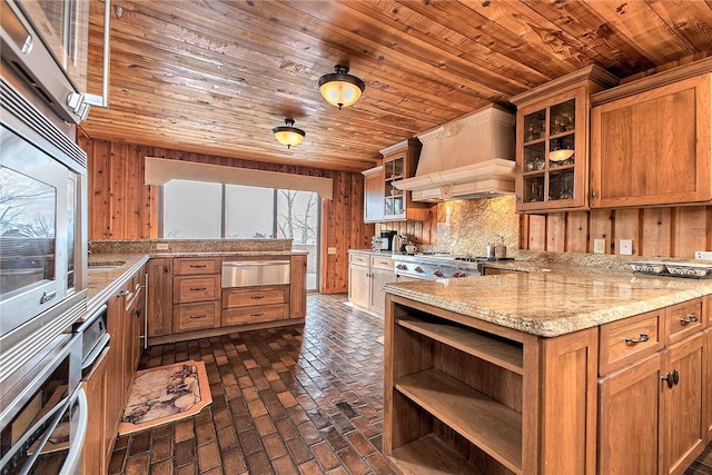 kitchen featuring appliances with stainless steel finishes, custom range hood, wooden walls, and wood ceiling