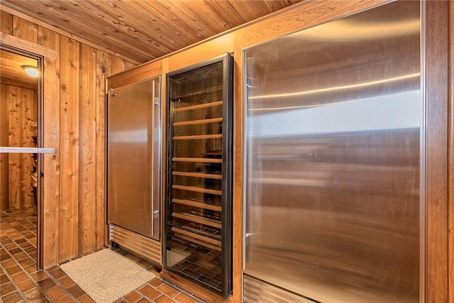 interior space featuring wooden walls, wooden ceiling, and beverage cooler