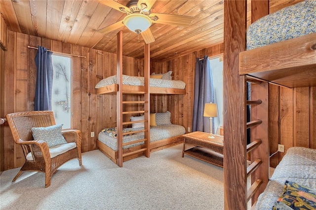 carpeted bedroom with wood ceiling and wood walls