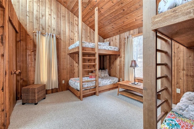 carpeted bedroom with wooden walls, vaulted ceiling, and wooden ceiling