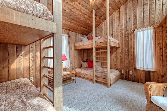 bedroom featuring wood ceiling, multiple windows, wooden walls, carpet, and vaulted ceiling