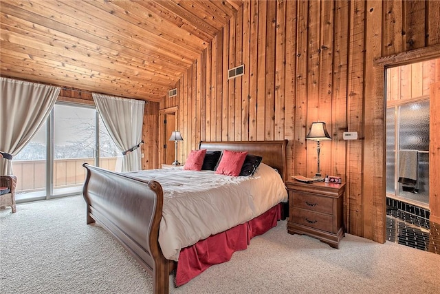 bedroom featuring access to exterior, wooden walls, and light colored carpet