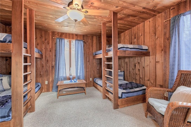 bedroom featuring wooden ceiling, carpet, and wood walls