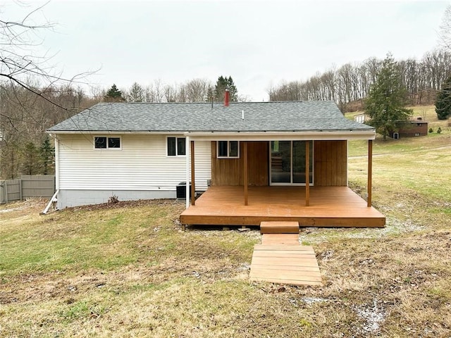 back of property with central AC, a deck, and a lawn