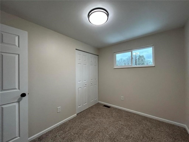 unfurnished bedroom featuring carpet flooring and a closet