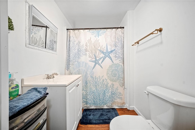 bathroom with a shower with curtain, vanity, hardwood / wood-style floors, and toilet