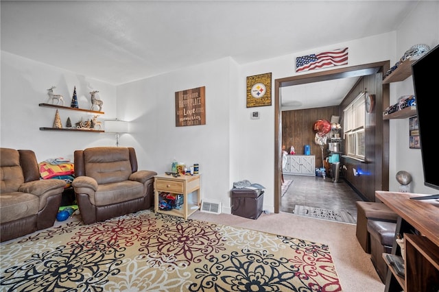 living room featuring carpet floors and wooden walls