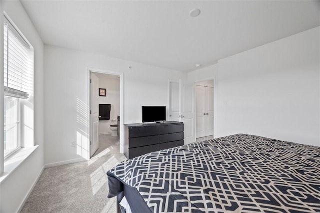 carpeted bedroom featuring ensuite bath