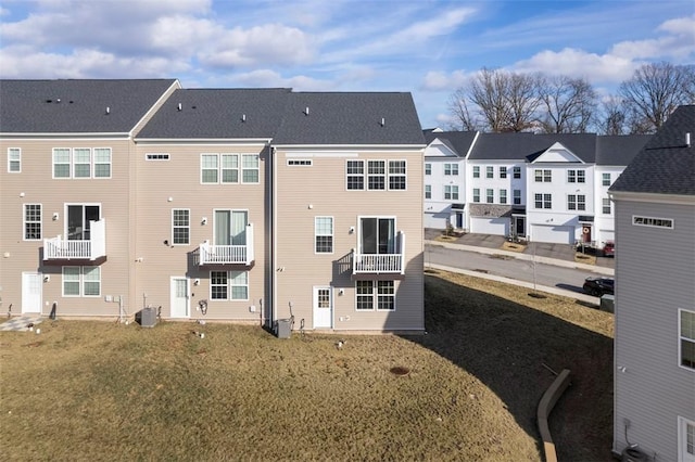 rear view of property with cooling unit and a yard