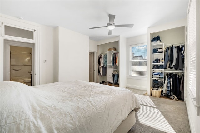 bedroom with two closets, light colored carpet, and ceiling fan