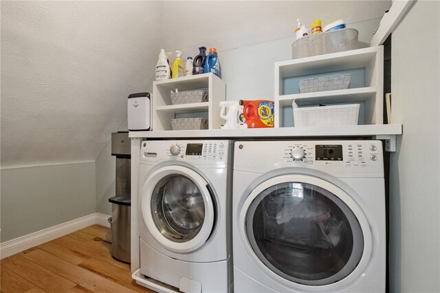 washroom featuring separate washer and dryer, a textured ceiling, and light hardwood / wood-style flooring