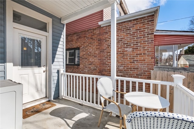 exterior space featuring a porch and washer / dryer