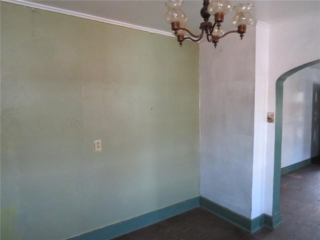 unfurnished room featuring an inviting chandelier and dark hardwood / wood-style flooring