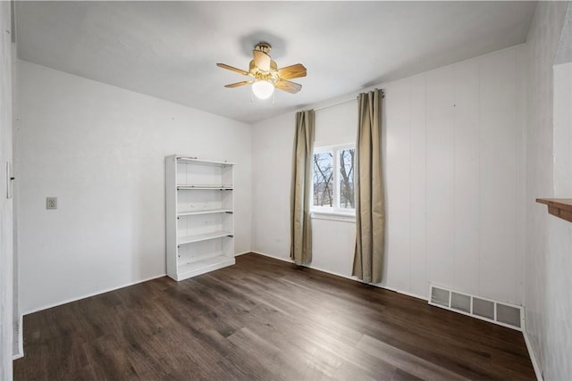 spare room featuring ceiling fan and dark hardwood / wood-style flooring