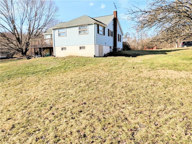 view of property exterior with a yard and a deck