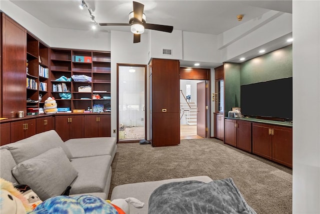 carpeted living room featuring rail lighting and ceiling fan