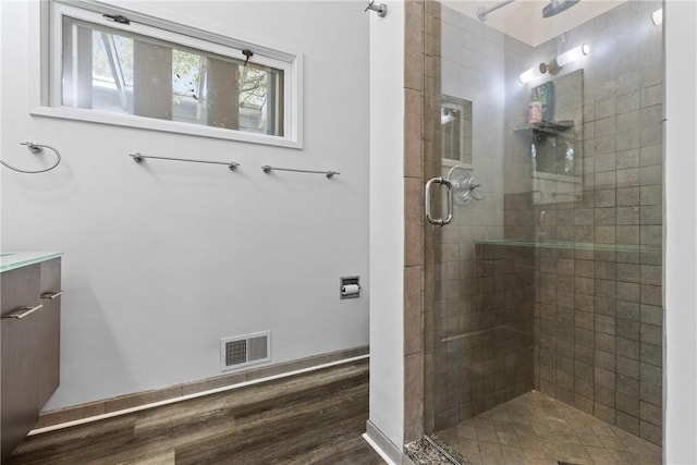 bathroom featuring vanity, hardwood / wood-style floors, and a shower with shower door