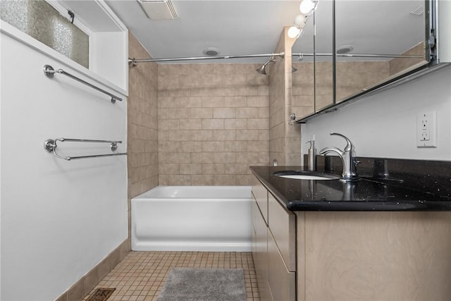 bathroom with tiled shower / bath combo, vanity, and tile patterned floors