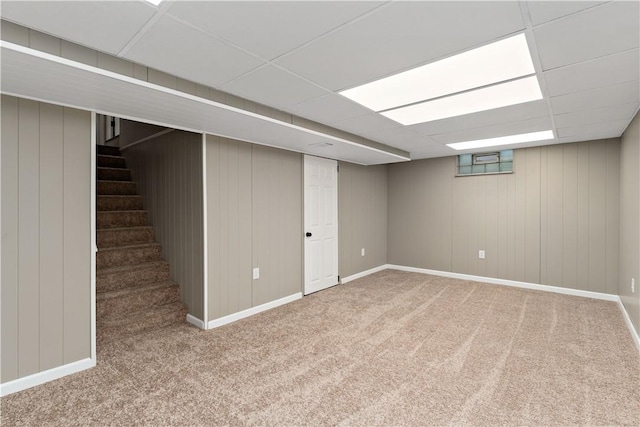 basement featuring a paneled ceiling and carpet flooring
